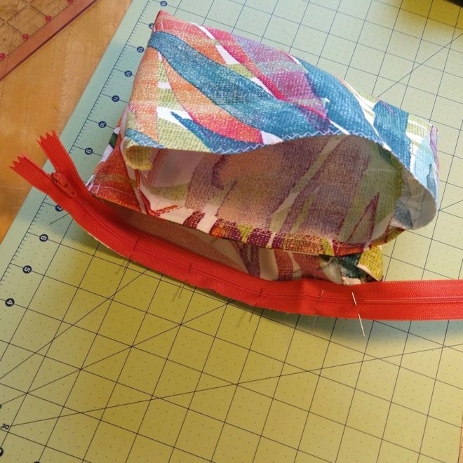 Zipper pinned to first edge of pouch