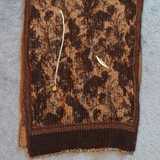 tree-patterned shawl with tiger eye necklace and leaf pin on top